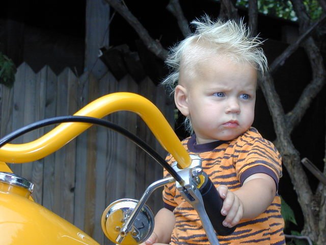 Malý chlapec sediaci na motorke